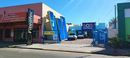 Vista da rua com a fachada azul da SOS Piscinas