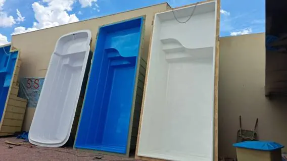Piscinas de fibra branca e azul em pé no pátio da loja SOS Piscinas